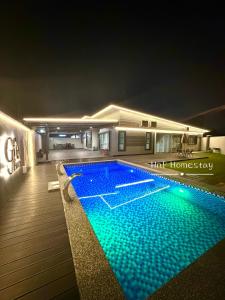 Gfe Home Villa Swimming Pool 20Pax 5Bedroom في ماساي: مسبح في وسط البيت في الليل