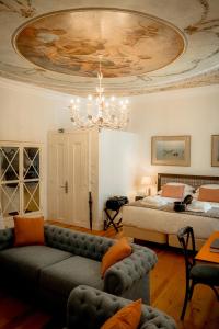 ein Wohnzimmer mit einem Sofa, einem Bett und einem Kronleuchter in der Unterkunft Once Upon Lisboa in Lissabon