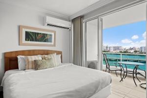 a bedroom with a bed and a balcony with a table at Condado Lagoon by Otium in San Juan +107 photos