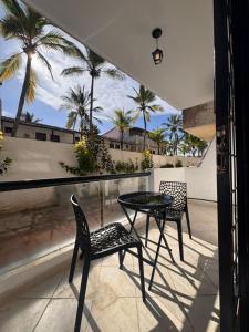 a table and two chairs on a balcony with palm trees at Apartamentos en la isla de Margarita in La Loma +6 photos