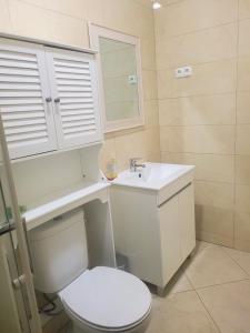 ein Badezimmer mit weißer Toilette und Waschbecken in der Unterkunft Castelinho Sal Lodge in Espargos + 20 Fotos