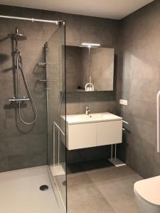 ein Badezimmer mit Waschbecken und Glasdusche in der Unterkunft O'Sea ref 104,105,106 in Koksijde + 25 Fotos