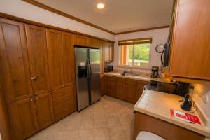 a kitchen with wooden cabinets and a stainless steel refrigerator at Veranda 8F - 2 bdr 2 bath - Condo in Isla Herradura +15 photos