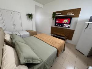 a bedroom with two beds and a tv on the wall at Apartamento Centro Manaus 721 in Manaus