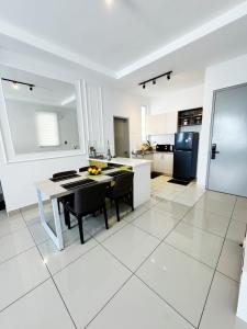 a large white kitchen with a table and chairs at Palmyra residence New condo in Kajang