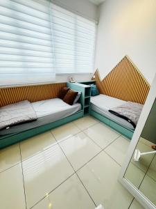 two beds sitting in a room with a window at Palmyra residence New condo in Kajang