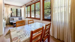 une salle à manger avec une table et quelques fenêtres dans l'établissement El racó de Montana Park, à Enveitg 20 autres photos