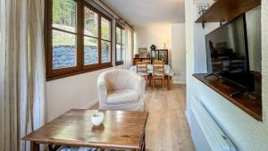 un salon avec une table, une chaise et une télévision dans l'établissement El racó de Montana Park, à Enveitg