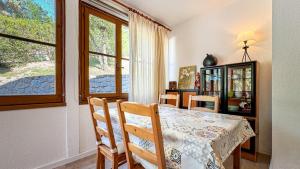 une salle à manger avec une table et des chaises et une fenêtre dans l'établissement El racó de Montana Park, à Enveitg