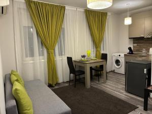 een woonkamer met een tafel en een keuken met gele gordijnen bij Апартамент Димана in Hisarya