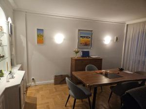 Chambre d'hôte dans appartement Lyon 69006 في ليون: غرفة معيشة مع طاولة وكراسي خشبية