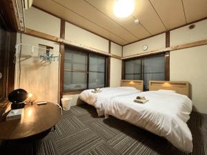 two beds in a room with a table and a tableasteryasteryasteryasteryastery at koto KAWASAKI in Kawasaki