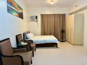 a room with a bed and a couch and a chair at The Infinity Condominium BGC at high Street in Sampong