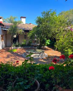 バジェ・デ・ブラボにあるOmbligo connection houseの噴水と赤い花のある庭園 +42枚の写真