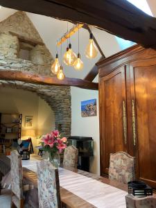 a dining room with a table and a stone wall at Escapade Bretonne in Rospez
