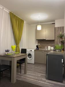 een keuken met een tafel en een wasmachine bij Апартамент Димана in Hisarya +6 foto's