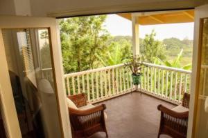 a porch with two chairs and a balcony with a view at Hale Hualalai in Kailua-Kona