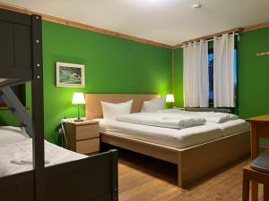 a green room with two beds and a green wall at Berggasthaus Auerhahn - Ski In- Ski Out- in Feldberg