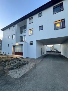 een groot wit gebouw met een parkeerplaats bij Bright & Cozy Central Studio in Reykjavík