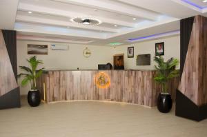 a lobby with a waiting area with two palm trees at Hotel Enigma in Owerri +13 photos