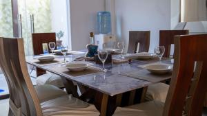 a dining room table with glasses and plates on it at Vacaciones Seguras -Conjunto Privado -Jacuzzi 