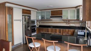 a kitchen with a black counter top and wooden cabinets at Vacaciones Seguras -Conjunto Privado -Jacuzzi 