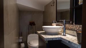 a bathroom with a bowl sink and a toilet at Vacaciones Seguras -Conjunto Privado -Jacuzzi 