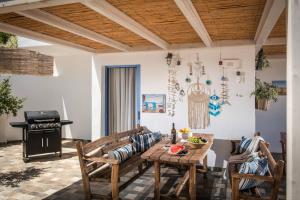 un soggiorno con tavolo, sedie e piano cottura di Villa Roza by Prime Stay a Stalida