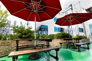 two picnic tables and two umbrellas on a patio at The Stay Hotel Myeongdong in Seoul
