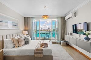 a bedroom with a large bed and a tv at Condado Lagoon by Otium in San Juan