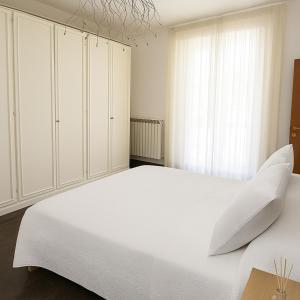 a white bedroom with a large white bed with pillows at Appartamento in Villa Monaco in Mosciano SantʼAngelo +6 photos