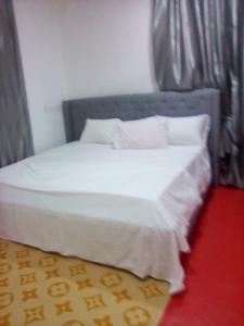 Regal Royal Suites : سرير بشرشف ووسائد بيضاء في الغرفة