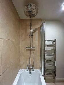 a bathroom with a bath tub and a shower at Daisy Cottage - Framlingham in Framlingham
