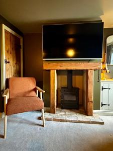 a living room with a tv and a fireplace at Daisy Cottage - Framlingham in Framlingham