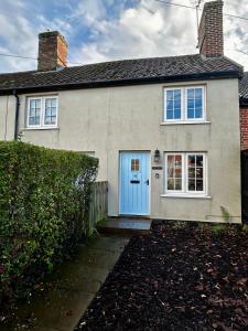 a white house with a blue door at Daisy Cottage - Framlingham in Framlingham