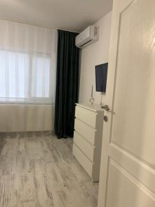 una stanza con una cassettiera, una tv e una porta di Amy's Home a Craiova