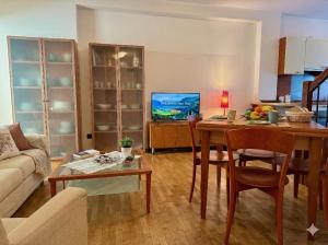 a living room with a table and a tv in it at Marconi Deluxe - Attico a Due Passi dal Mare in Lido di Jesolo
