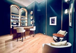 a blue room with a bar with white stools at Signature 2BR Apartment ARC100 Vasa Suite Surabaya City Centre with Balcony by Le Ciel Hospitality in Surabaya