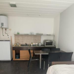 a kitchen with a table and chairs and a microwave at Complejo Eco-Apart SomoS in Colón