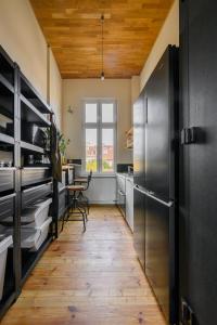 a kitchen with stainless steel appliances and a wooden ceiling at Boogas House - Gdańsk in Gdańsk