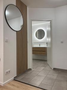 a bathroom with a mirror and a sink at Modern apartment with feel-good factor in Gravenwerth