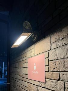a light on a brick wall with a sign on it at koto KAWASAKI in Kawasaki +8 photos