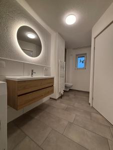 a bathroom with a sink and a mirror at Modern apartment with feel-good factor in Gravenwerth