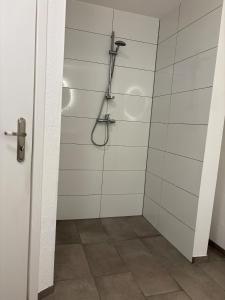 a bathroom with a shower with white tiles at Modern apartment with feel-good factor in Gravenwerth +2 photos