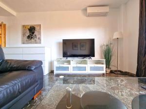 een woonkamer met een bank en een flatscreen-tv bij Close To The Beach, With A Pool 224 in Las Lagunas Mijas