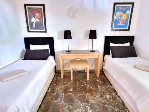 een kamer met 2 bedden en een bureau ertussen bij Close To The Beach, With A Pool 224 in Las Lagunas Mijas +22 foto's