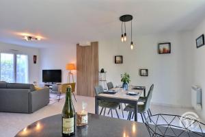 普勒尔蒂La voie verte的客厅配有一张桌子,并提供一瓶葡萄酒