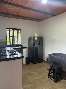 a kitchen with a black refrigerator and a table at Casa Campestre acogedora y con aventura al alcance in San Gil