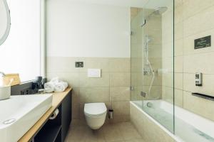a bathroom with a toilet and a glass shower at harry's home Zürich-Limmattal in Spreitenbach