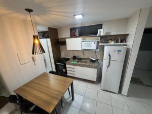 een kleine keuken met een tafel en een koelkast bij Conforto na Ponta Verde in Maceió